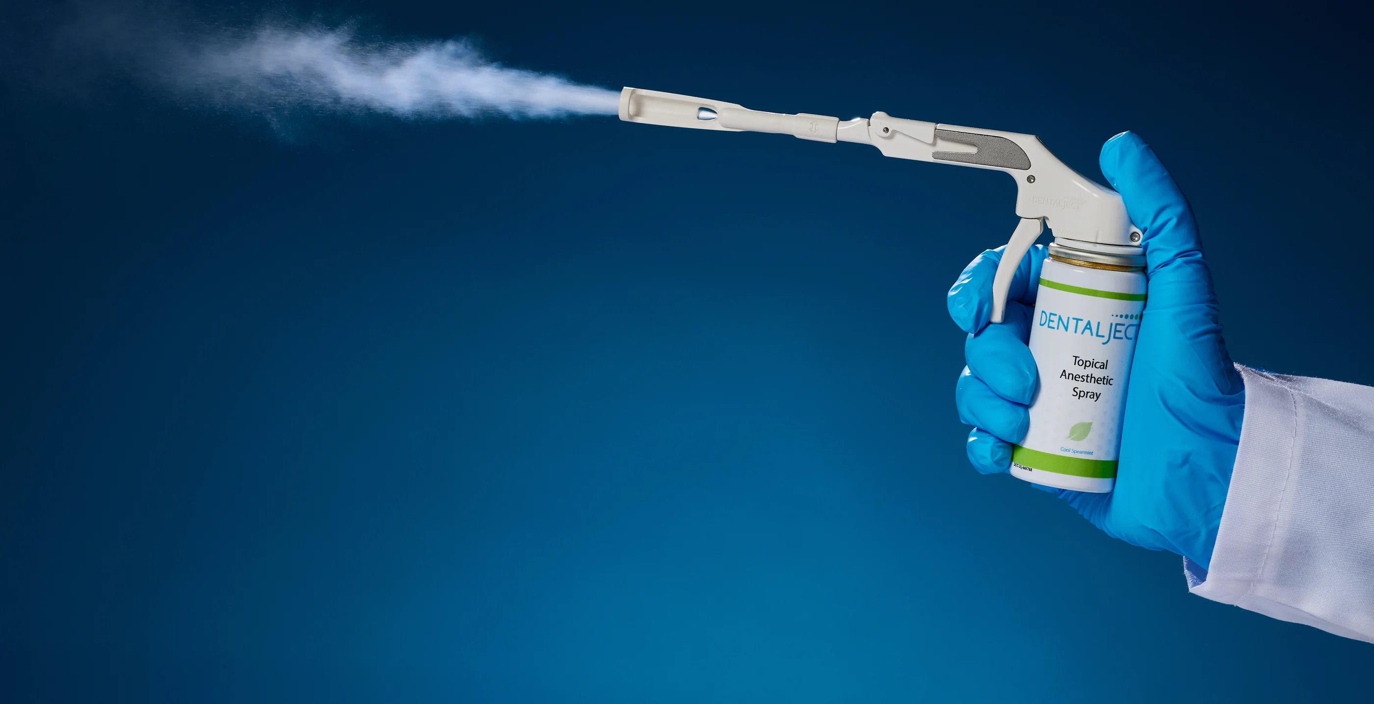 A gloved clinician spraying DentalJect topical anesthetic